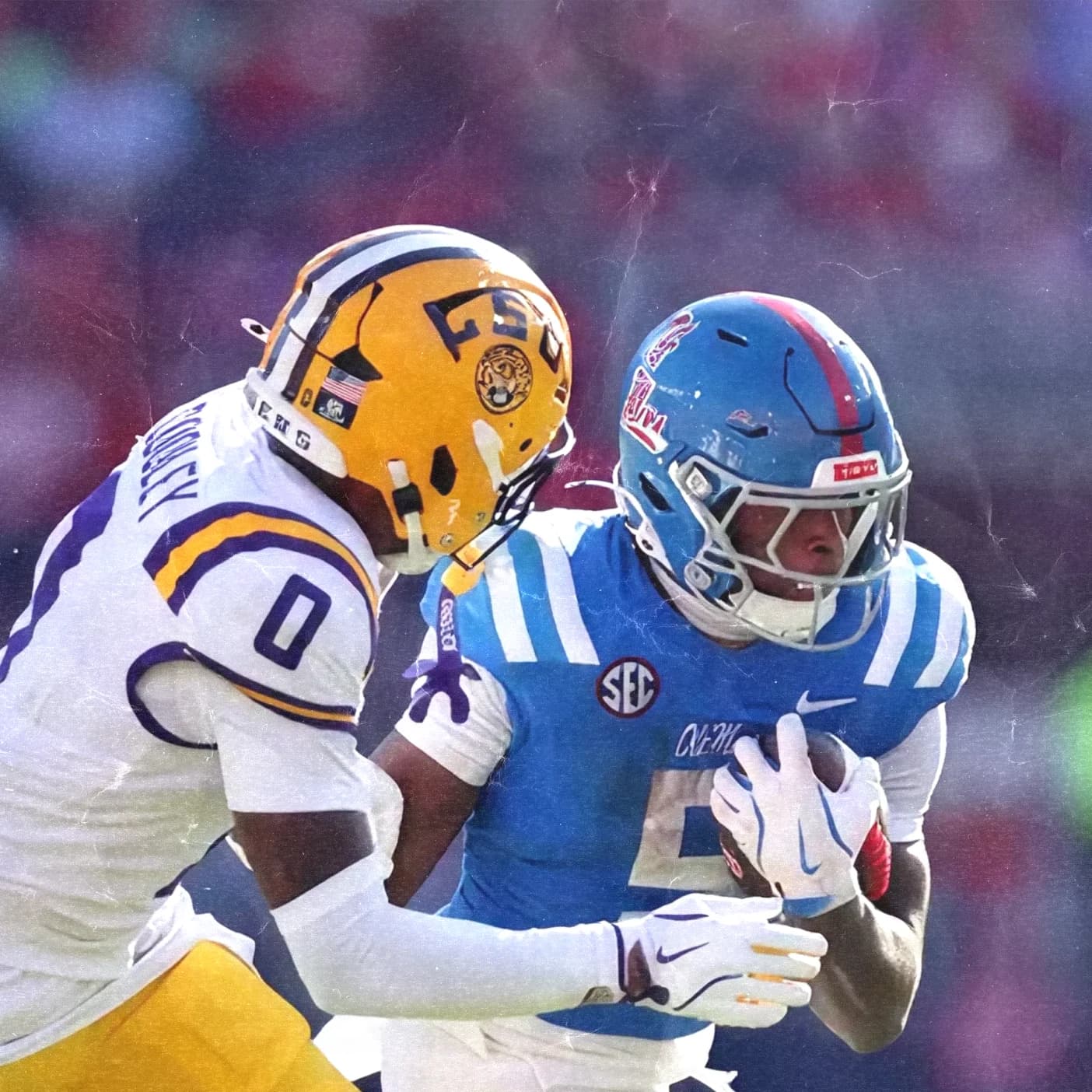 An LSU defensive back in purple and gold wraps up an Ole Miss ball carrier in powder blue during the Week 3 college football matchup