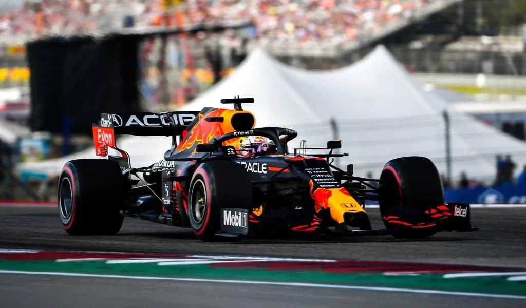 A Red Bull Formula 1 car races at Circuit of the Americas with a crowd in the background.