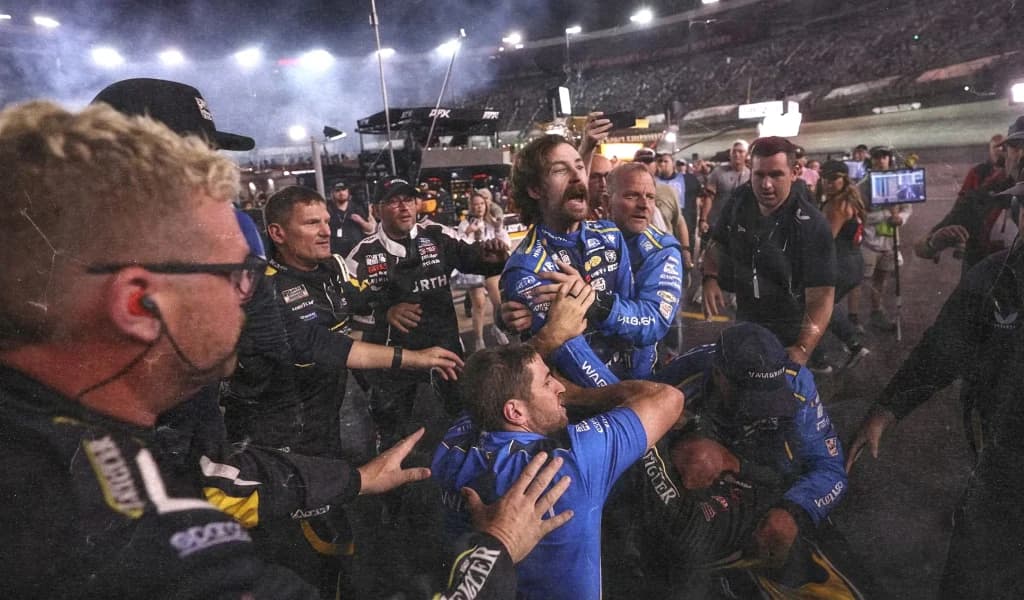 Race crew celebrates wildly on pit road at night