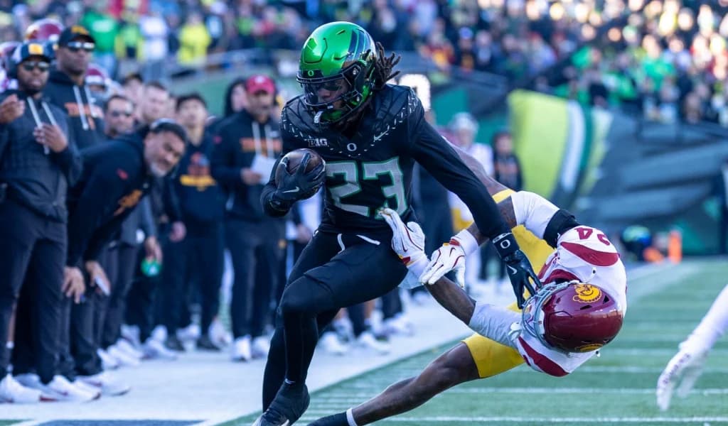 Oregon Ducks running back stiff-arms a USC Trojans defender along the sideline