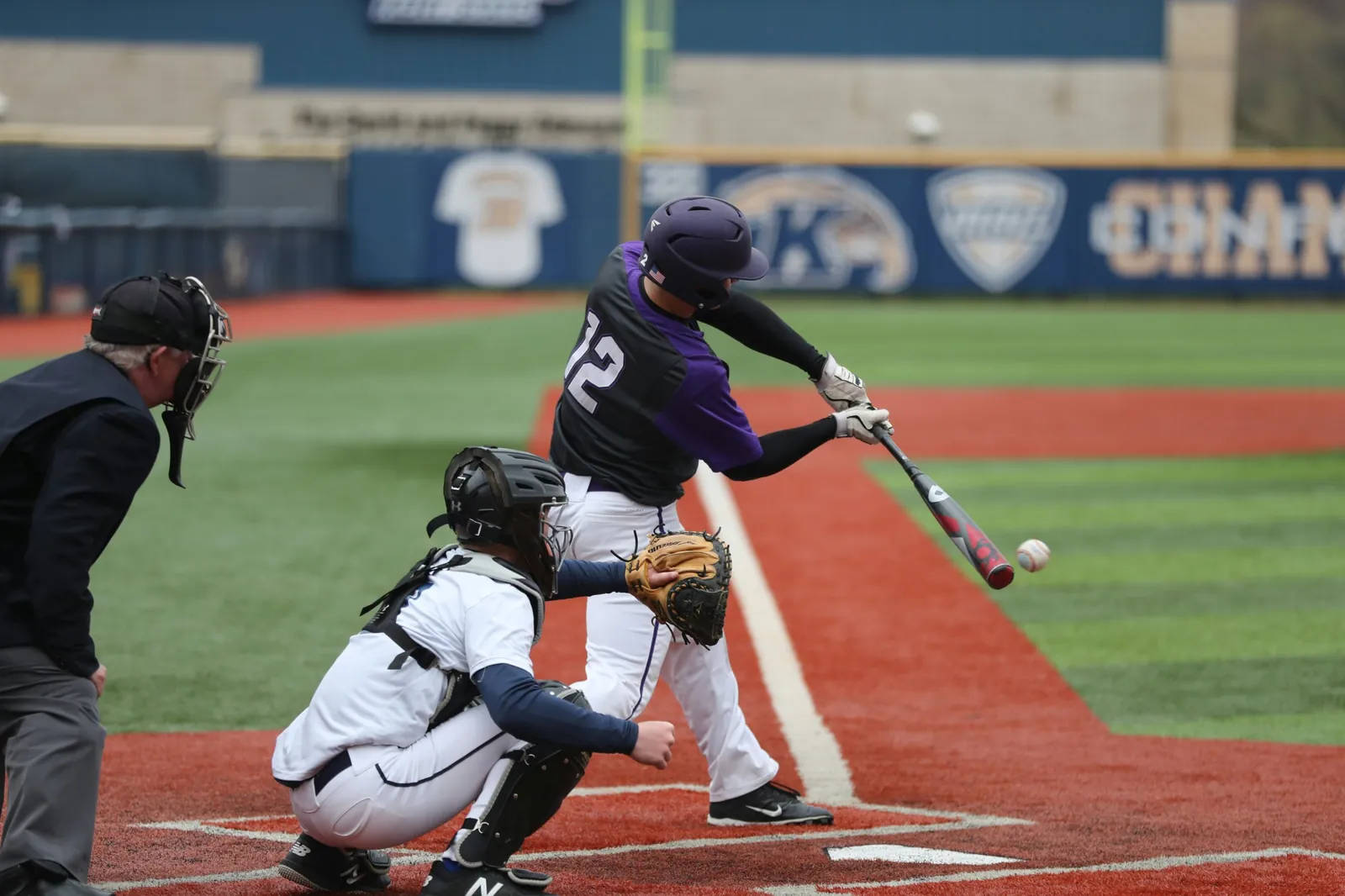 Batter swings at a pitch as the catcher and umpire look on