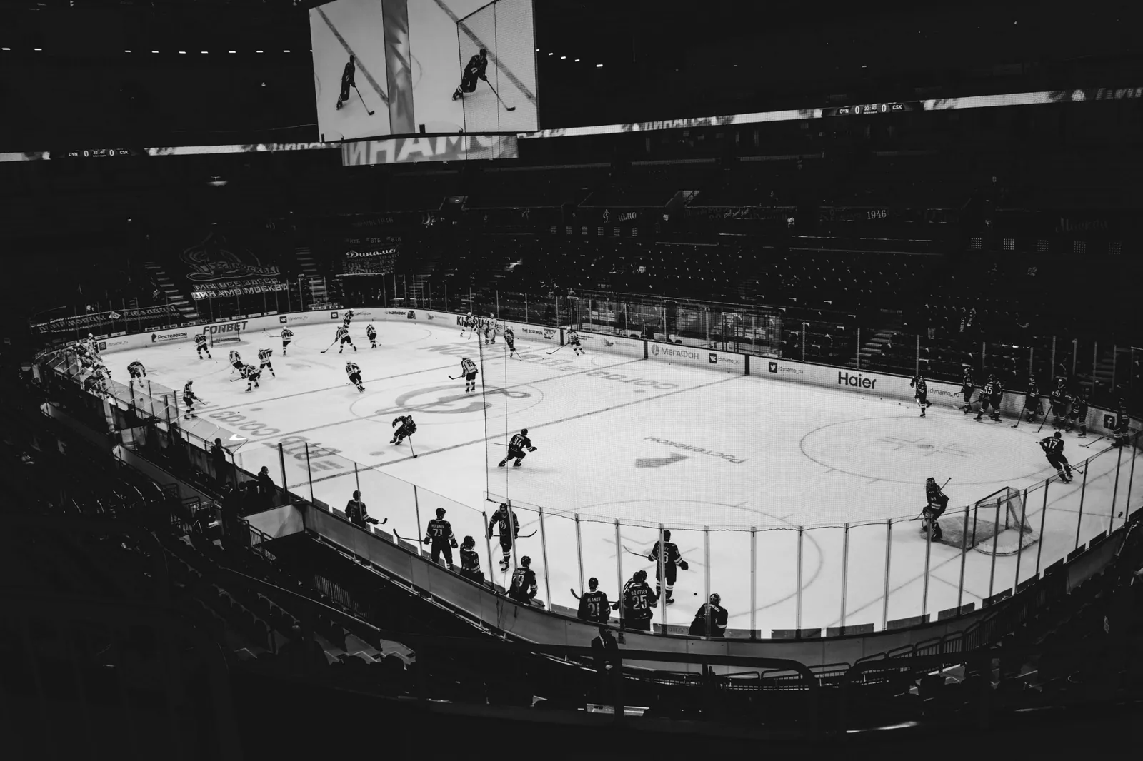 Black-and-white view of hockey players warming up on an indoor rink